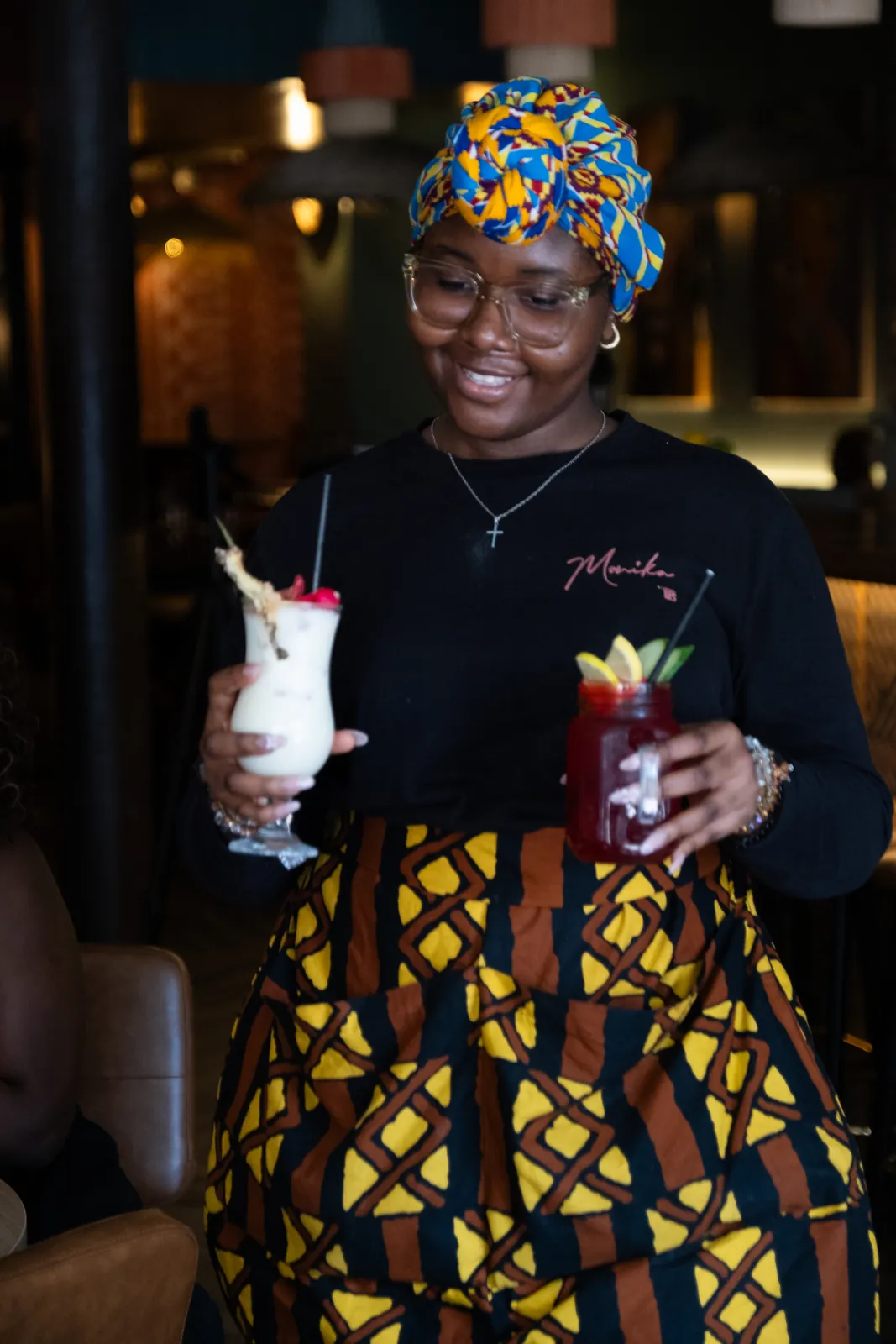 A member of the team serving colourful cocktails