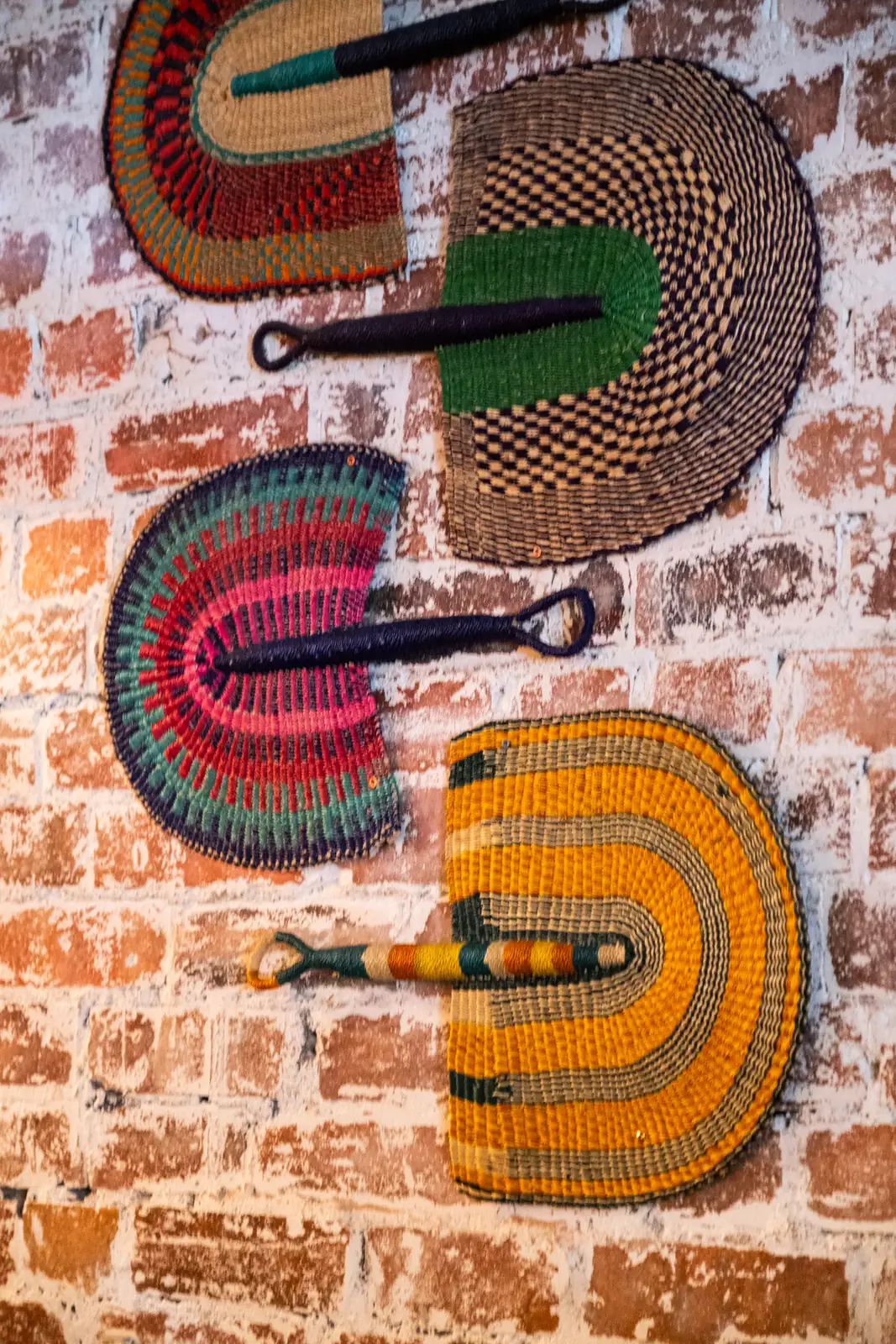 Colourful woven artwork on the brick wall