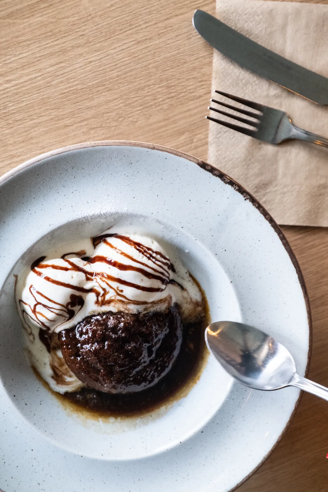 A warm dessert with ice cream and chocolate sauce